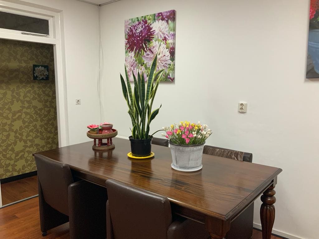 De tafel in de ontvangstruimte met bloemen en een schaaltje met lotusbloemen.